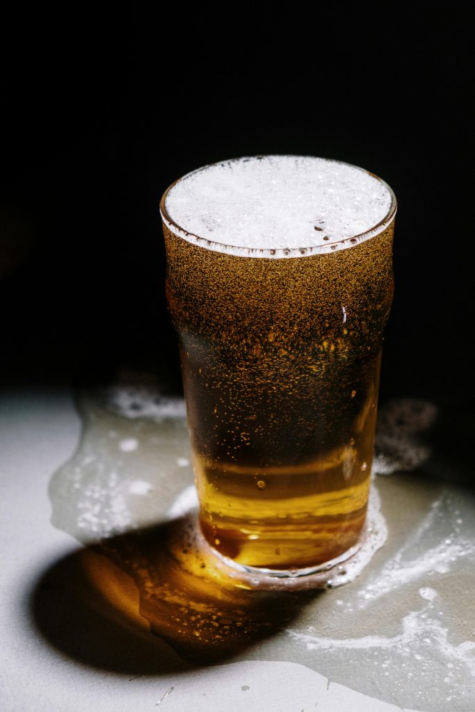 Close-up shot of a refreshing beer with foam overflowing, perfect for Oktoberfest themes.
